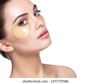 リフトアイパッチを適用した新鮮な毎日のメイクアップを持つ美しい女性の顔。目の下の皮膚に潤いとさわやかさを与えるパッチ