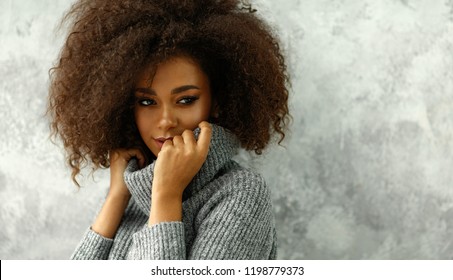 Porträt der jungen schwarzen Frau mit einem Afro-Haar tragen hochgeschlossene Wolle und Kaschmirpullover