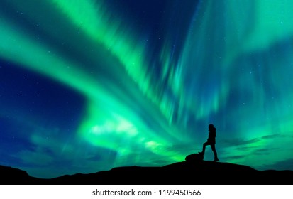 Aurora Borealis mit Silhouette stehender Mann auf dem Berg. Reisekonzept für Freiheitsreisende
