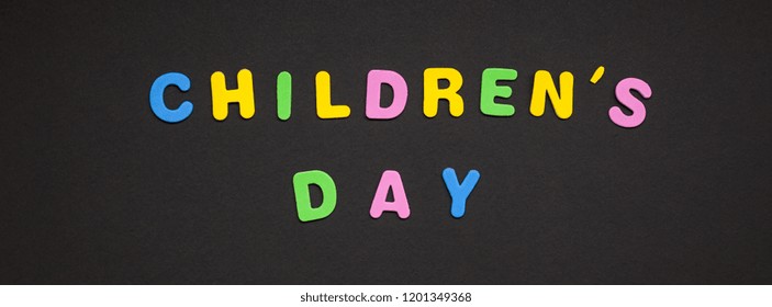 Creatieve kleurrijke tekst gemaakt van plastic letters Kinderdag schrijven op zwarte papieren achtergrond met kopieerruimte. Vakantie bericht concept, viering kaartsjabloon
