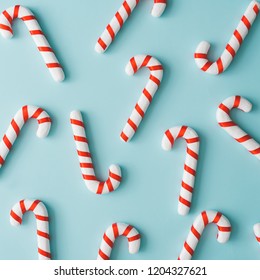 創造的な最小限のクリスマス アート。明るい青の背景にクリスマス キャンディーで作られたパターン。フラットレイ。スペースをコピーします。最小限の構成。