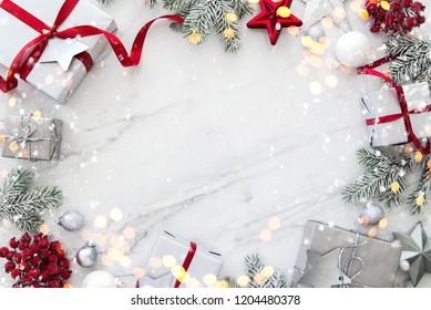 Chrëschtdagsgeschenkskëschten aus Sëlwer, handgemaach, op wäissem Marmorhannergrond, Vue vun uewen. Schéi Chrëschtdagsgréisskaart, Kader. Wanter-Chrëschtdags-Feierdagsthema. Glécklecht Neit Joer. Flaach lay