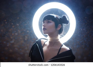 concept of artificial life. Beautiful young woman, futuristic style. Portrait against a glowing circle