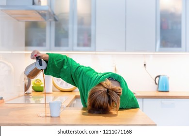 Mujer cansada durmiendo en la mesa de la cocina durante el desayuno. Tratando de beber café de la mañana