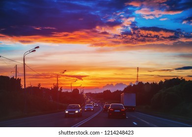 Auto's rijden bij zonsondergang op de weg in de zomermist