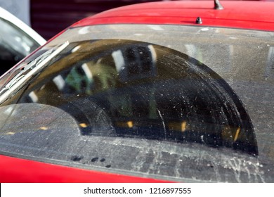 汚れた車のガラスのある洗車の概念的な背景、汚れやほこりで汚れたリアウィンドウハッチバックのクローズアップ。