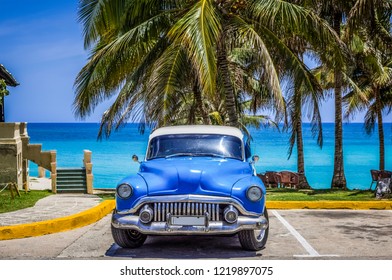 Varadero, Cuba - June 21, 2017: HDR - American blue Buick classic car parked under palms on the beach in Varadero Cuba -Serie Cuba Reportage