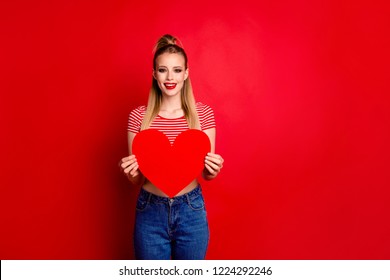 Portrait of cute cheerful charming attractive magnificent good-looking girl with pony-tail holding in hands big paper heart isolated over bright vivid red background