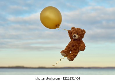 Teddybär fliegt in einem gelben Ballon durch den Himmel. Bär mit gelbem Ballon.