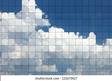 近代的なオフィスビルの窓に映る雲