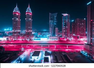 Prachtig uitzicht naar Dubai en Sheikh Zayed Rd, Verenigde Arabische Emiraten. Skyline van de stad. Lange blootstelling effect 's nachts. Duotone retro wave neon noir lichten kleur getint