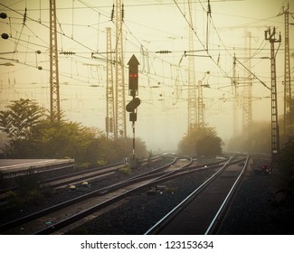 Moble Photography theo kiểu lo-fi hình ảnh đường ray xe lửa đô thị khó hiểu với dây cáp và dây cáp trên cao và đèn tín hiệu màu đỏ vào lúc hoàng hôn đầy sương mù