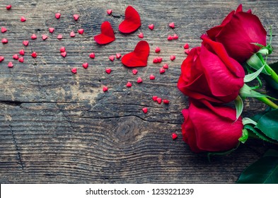 Flores de rosas rojas con corazones rojos sobre fondo de madera antiguo con lugar para texto. Concepto romántico de vacaciones de San Valentín. Tarjeta de felicitación del día de San Valentín. Copie el espacio. Vista superior.