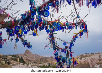 Capadocia, Turquía, Uchisar: Árbol colgando amuletos de Nazar, un objeto especial en forma de ojo que protege contra el mal de ojo