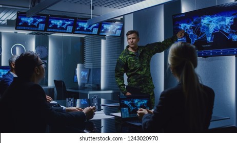 Hooggeplaatste militair houdt een briefing voor een team van regeringsagenten en politici, toont satellietbewakingsbeelden.