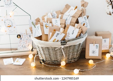 Lịch mùa vọng chờ Giáng sinh. Bộ sưu tập những món quà nhỏ được gói bằng giấy thủ công trong giỏ với các con số và nhiệm vụ cho trẻ em. Truyền thống theo mùa