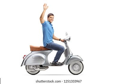Disparo de longitud completa de un joven montando un scooter vintage y saludando aislado sobre fondo blanco.