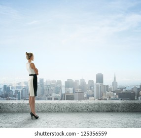 mujer de negocios en el techo mirando la ciudad