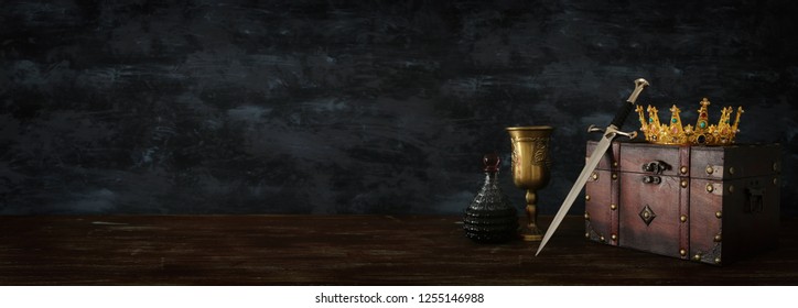 low key banner of beautiful queen/king crown, chest and sword. fantasy medieval period