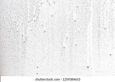 white isolated background water drops on the glass / wet window glass with splashes and drops of water and lime, texture autumn background