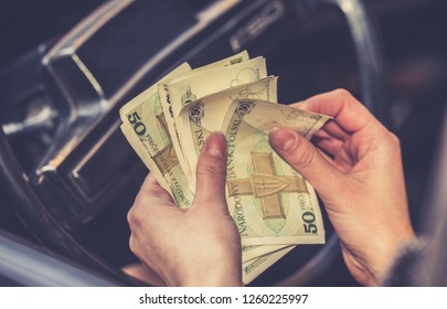 vrouw telt geld in de auto