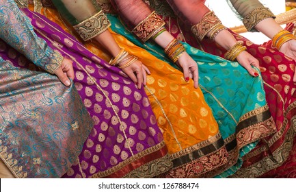 Bollywood-Tänzer halten ihre lebhaften Kostüme in der Hand. Hände sind in einer Reihe