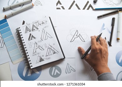 Graphic designer drawing sketch design creative Ideas draft Logo product trademark label brand artwork. Graphic designer studio Concept.