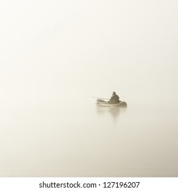 インフレータブル ボートの漁師、濃い白い朝の霧の湖。雰囲気のあるモノクロの白黒風景。釣り、趣味のスポーツ、レクリエーション、エコツー リズム、沈黙、孤独の概念