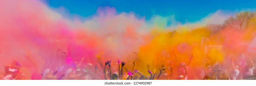 Crowd throwing bright coloured powder paint in the air, Holi Festival Dahan
