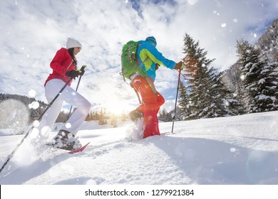 Pejalan sepatu salju berlari di butiran salju dengan cahaya matahari terbit yang indah. Aktivitas musim dingin di luar ruangan dan gaya hidup sehat