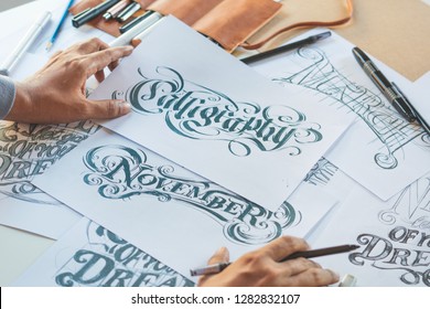 Типографський художник каліграфії дизайнер малювання ескіз пише, дозволяючи написані написаною ручкою пензля чорнила папір настільних ілюстрацій. Студія дизайну робочих місць.