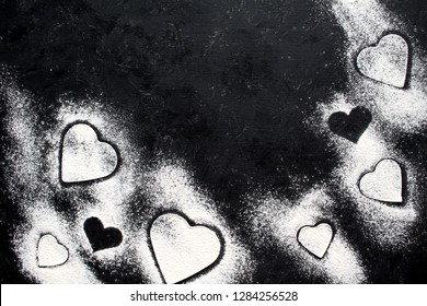 Baking background with flour and heart on dark background. Top view for Valentine's Day or Mather's Day. Flat lay. Valentine's Day cooking.