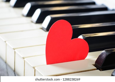 Coração vermelho brilhante em um teclado de um piano antigo. Conceito de amor, dia dos namorados