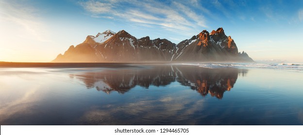 Zwart zandstrand op de landtong Stokksnes aan de zuidoostelijke kust van IJsland met Vestrahorn (Batman Mountain) Kleurrijke zomerochtend IJsland, Europa. Zonsondergangfoto op het schiereiland Stokksnes. Beste bergen