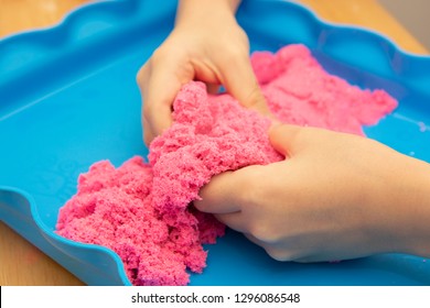 Creative play for children. Education and games. Children playing with pink motion sand.