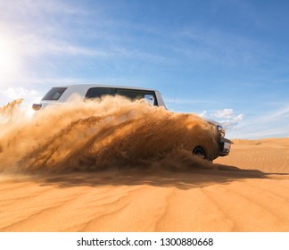 Coche todoterreno 4x4 a la deriva en el desierto. Congelar el movimiento de la explosión de polvo de arena en el aire. Actividad de acción y ocio.