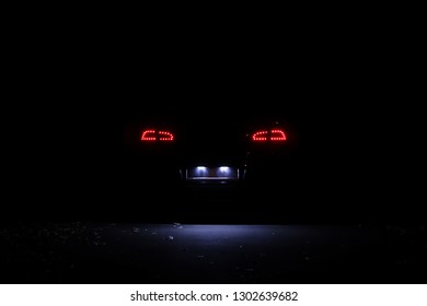 LED-Rücklichter moderner Autos bei Nacht. Kennzeichenbeleuchtung
