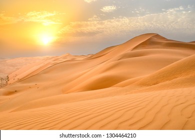 アブダビ、アラブ首長国連邦郊外の空き地 (アラビア砂漠) のなだらかな砂丘の端に沈む夕日