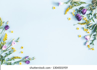 Blumenzusammensetzung. Gelbe und purpurrote Blumen auf pastellblauem Hintergrund. Frühling, Osterkonzept. Flache Lage, Draufsicht, Kopierbereich