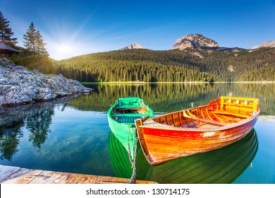 Reflection in water of mountain lakes and boats. Black lake in Durmitor national park in Montenegro, Europe. Beauty world.