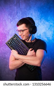 カラフルなピンクと青のネオンが輝く壁の上でゲーム用キーボードを持つプロの少年ゲーマー。ゲーム ゲーマーのコンセプト