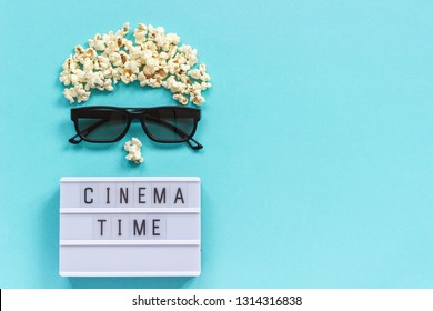 Abstract beeld van kijker, 3D-bril, popcorn en lichtbaktekst Cinema-tijd op blauwe papieren achtergrond. Concept bioscoopfilm en entertainment Plat leggen Bovenaanzicht Kopieer ruimte voor tekst of uw ontwerp.