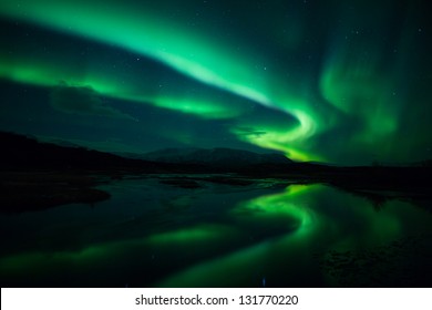 Reflexion der Nordlichter (Aurora borealis) über einem See in Island
