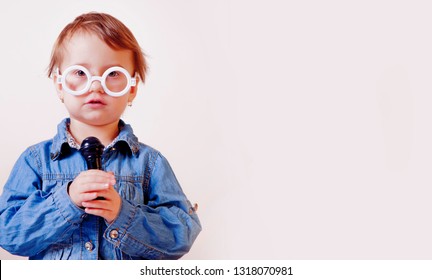 The famous actress. Humorous image of little cute child girl singing with a microphone. Happy childhood, music, child development concept.