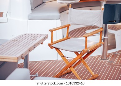 甲板船やヨットの上に立つ木製の折りたたみ椅子。