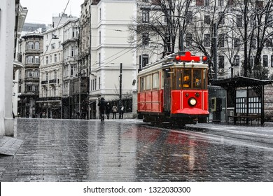 Rote nostalgische Straßenbahn fährt am Wintertag mit Schnee auf der Istiklal-Straße. Die Istiklal-Straße ist das beliebteste Ziel in Beyoglu, Taksim, Istanbul