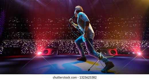 Selebriti bintang rock di panggung utama festival musik besar. Di sekitar stadion penuh penonton. penggemar memegang senter