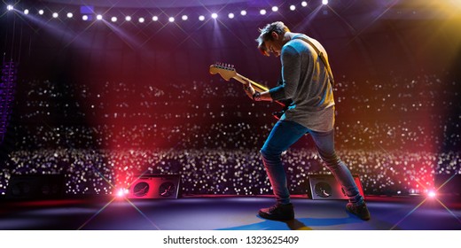 メイン ステージの大きな音楽祭のロック スターの有名人。観客でいっぱいのスタジアムの周り。ファンは懐中電灯を持っています