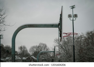 Basketball hoop covered in ice after a snowstorm.