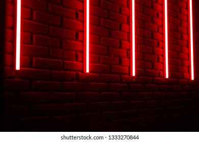 Linee rosse al neon su un muro di mattoni in una discoteca.